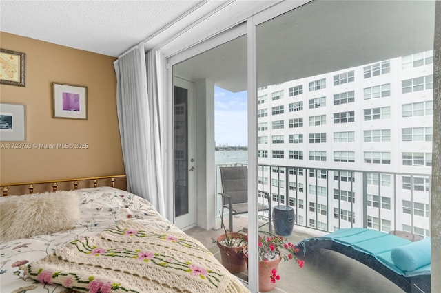 bedroom featuring a water view and a textured ceiling