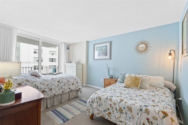 carpeted bedroom with a textured ceiling and a wall of windows