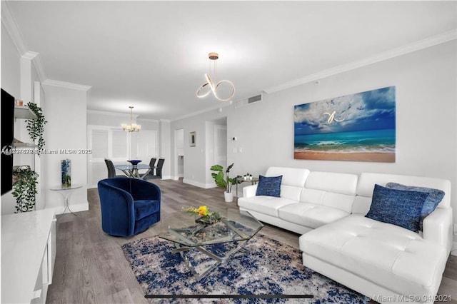 living room with hardwood / wood-style floors, crown molding, and a chandelier