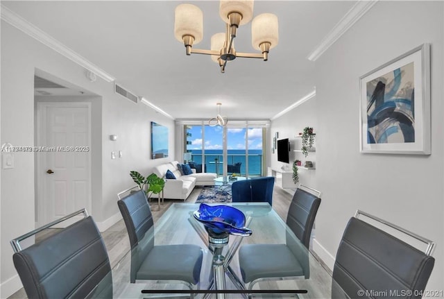 dining space featuring light hardwood / wood-style floors, crown molding, expansive windows, and a notable chandelier