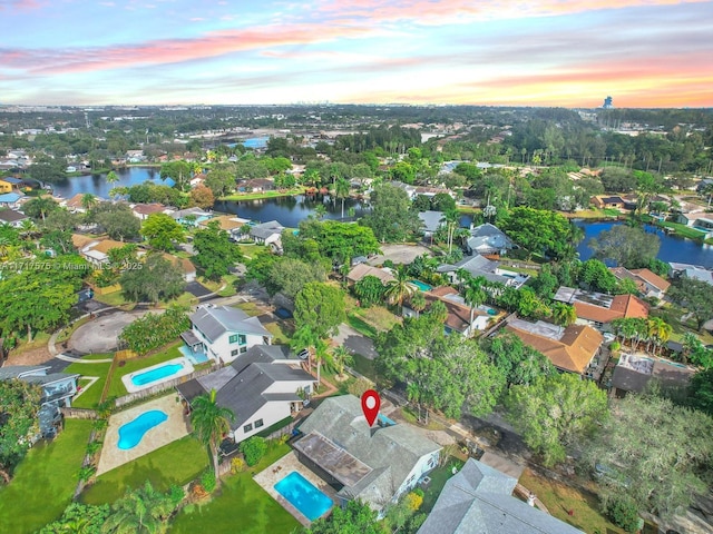 aerial view at dusk featuring a water view