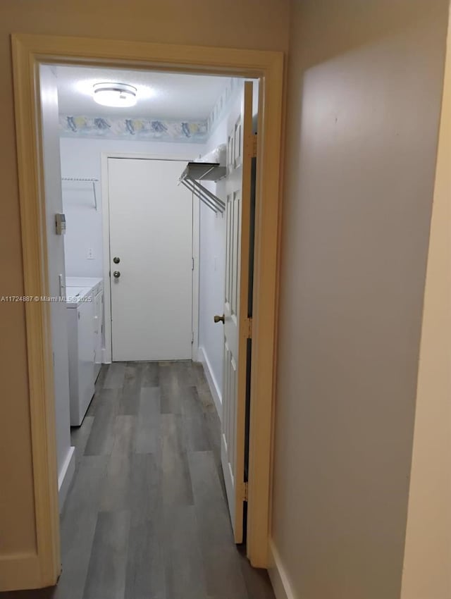 corridor with washing machine and clothes dryer and hardwood / wood-style floors