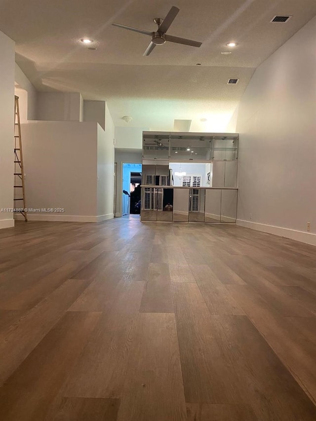 unfurnished living room with visible vents, baseboards, ceiling fan, and wood finished floors