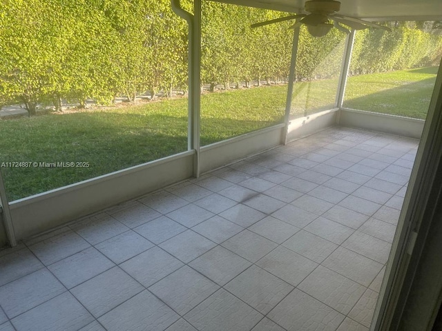 unfurnished sunroom featuring a ceiling fan