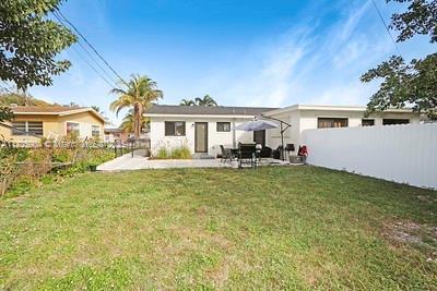 back of property with a yard and a patio