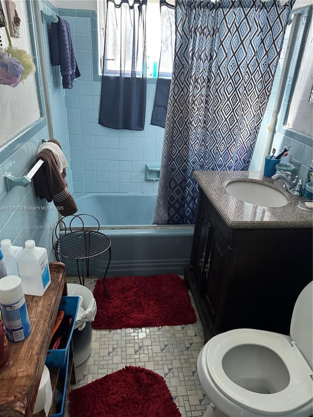 full bathroom with vanity, shower / bathtub combination with curtain, toilet, and tile walls