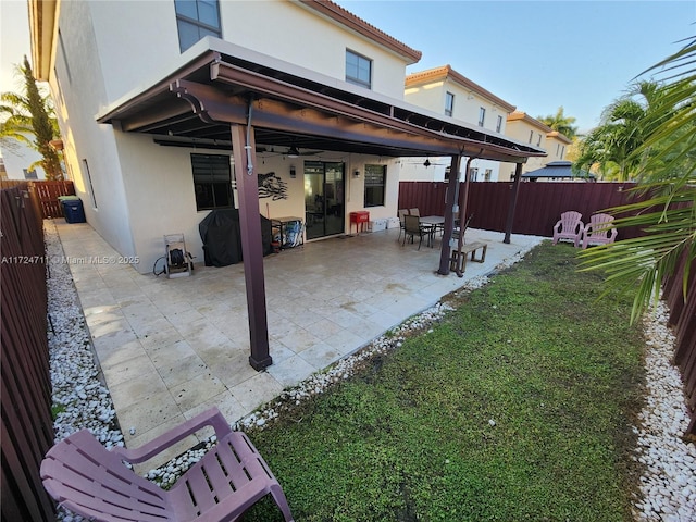 rear view of house with a patio and a lawn