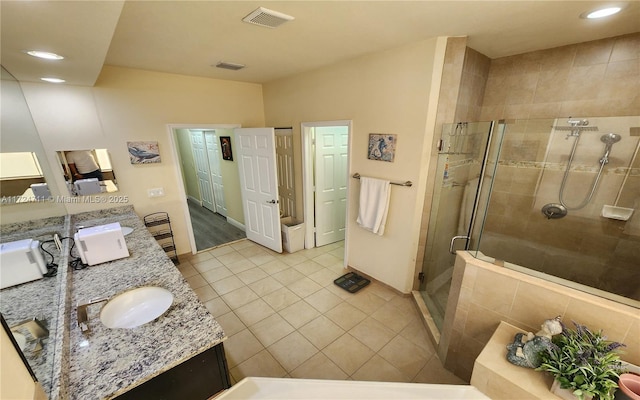 bathroom with tile patterned flooring, vanity, and walk in shower