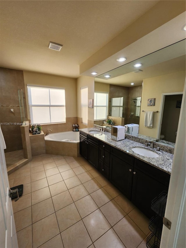 full bathroom with plus walk in shower, tile patterned flooring, vanity, and toilet