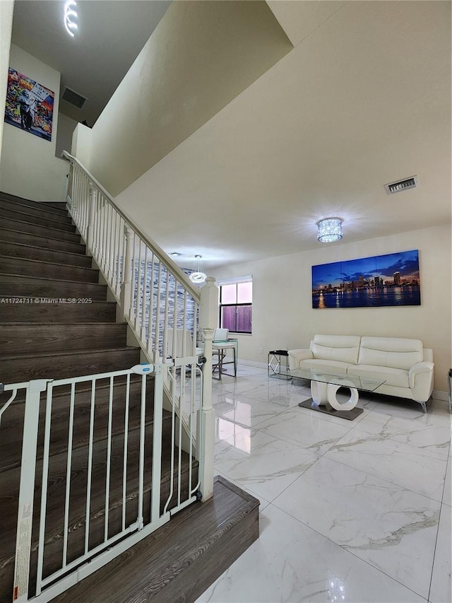 stairs featuring a notable chandelier