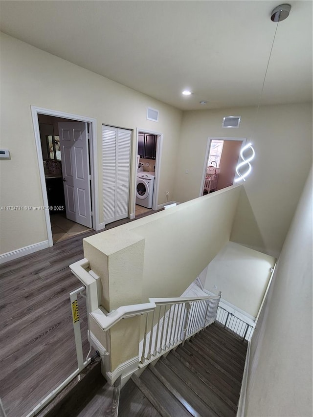 staircase with washer / dryer and hardwood / wood-style floors