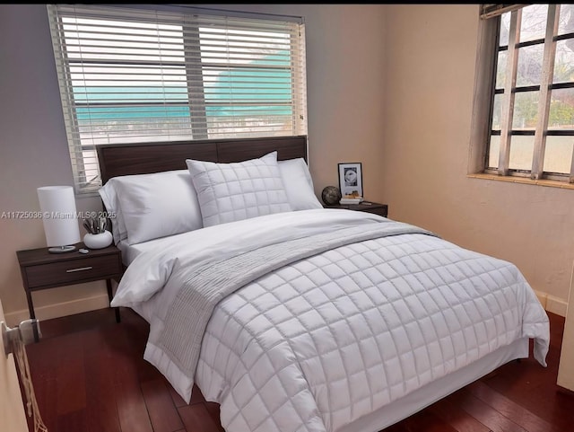 bedroom with dark hardwood / wood-style flooring