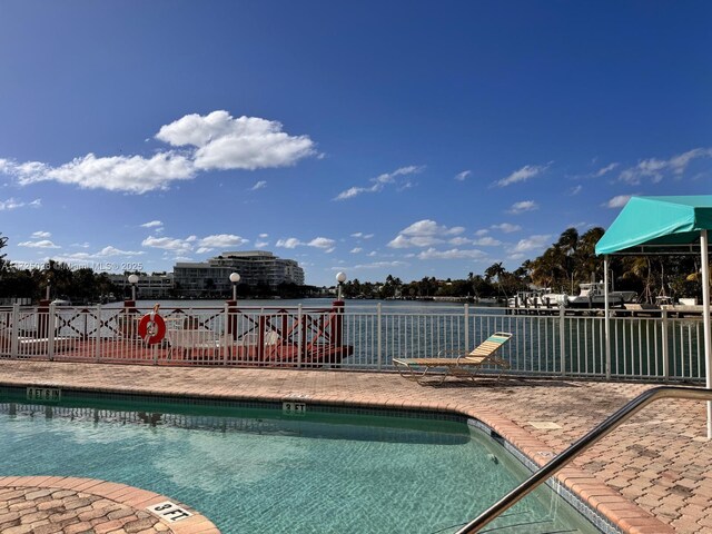 view of swimming pool with a water view and a patio area