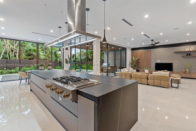 kitchen featuring expansive windows, hanging light fixtures, ceiling fan, light tile patterned floors, and island exhaust hood