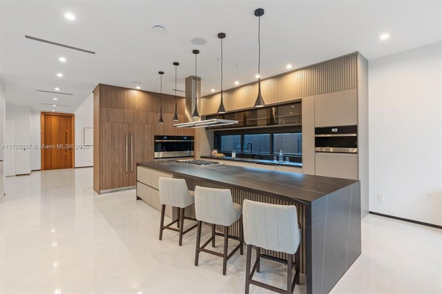 kitchen with island exhaust hood, stainless steel oven, a center island, and pendant lighting