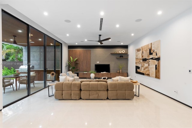 tiled living room with ceiling fan and floor to ceiling windows