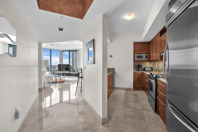 kitchen with appliances with stainless steel finishes, tasteful backsplash, and expansive windows