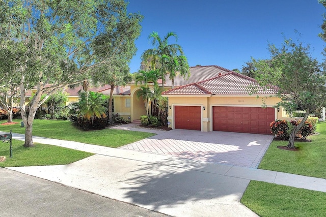 mediterranean / spanish-style house with a garage and a front lawn