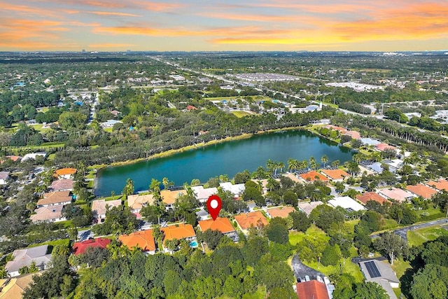 aerial view at dusk featuring a water view