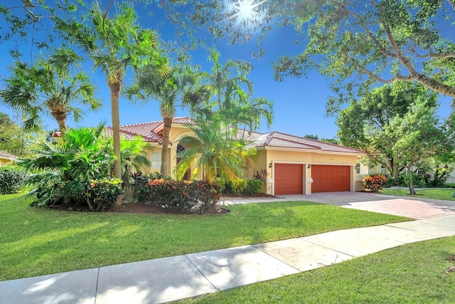 mediterranean / spanish-style house featuring a garage and a front yard