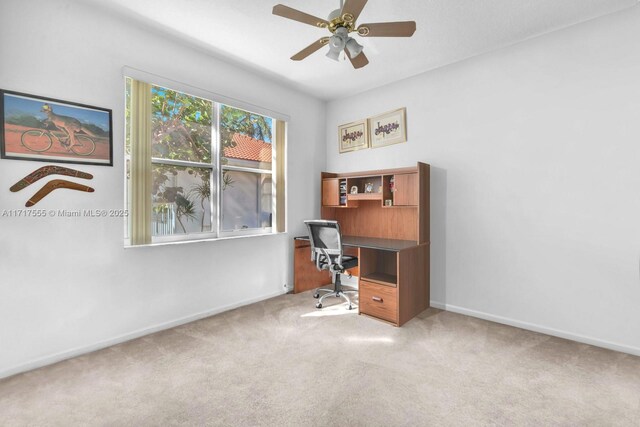 carpeted office featuring ceiling fan