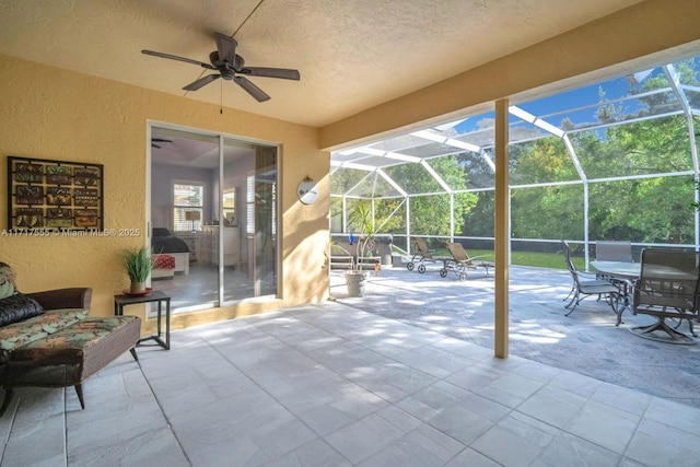 view of patio / terrace featuring ceiling fan and glass enclosure