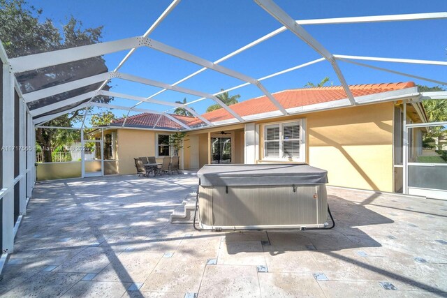 view of patio featuring a lanai and a hot tub