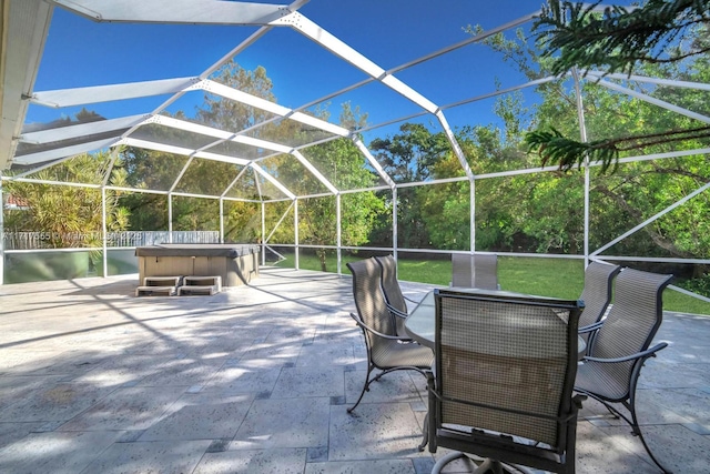 view of patio / terrace with a hot tub and glass enclosure