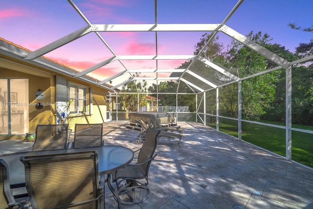 patio terrace at dusk featuring glass enclosure