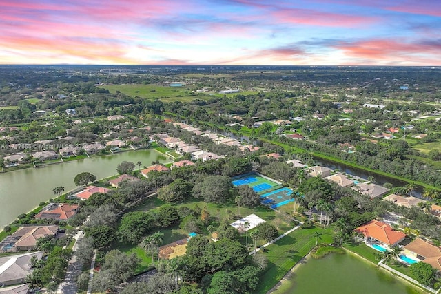 aerial view at dusk featuring a water view