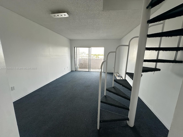 interior space featuring carpet and a textured ceiling