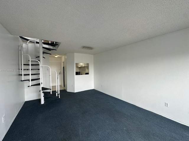 unfurnished living room featuring a textured ceiling and dark colored carpet