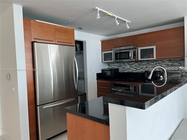 kitchen with tasteful backsplash, kitchen peninsula, black appliances, and track lighting