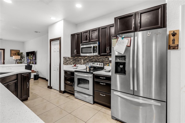 kitchen featuring dark brown cabinetry, light tile patterned floors, decorative backsplash, stainless steel appliances, and light countertops