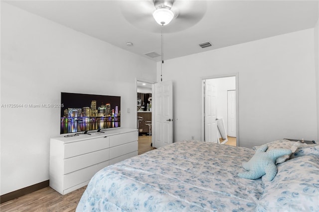 bedroom with light wood finished floors, visible vents, and baseboards