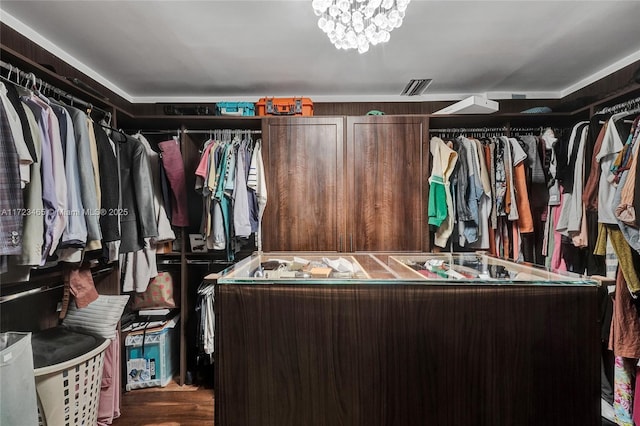 spacious closet featuring hardwood / wood-style flooring and a chandelier