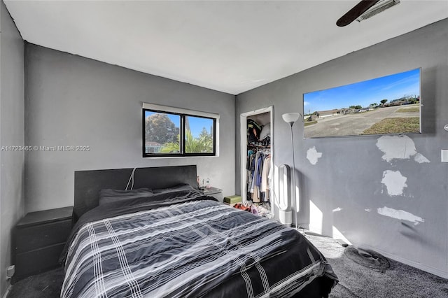 carpeted bedroom with ceiling fan, a closet, and a walk in closet