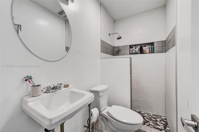 bathroom with sink, a shower, and toilet