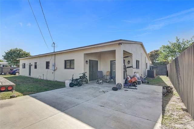 rear view of property with central AC unit and a patio