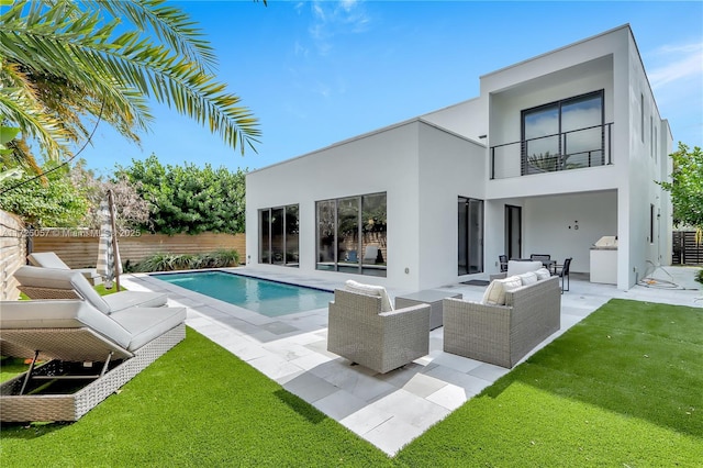 back of property with an outdoor living space, fence, a balcony, and stucco siding