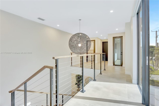 hallway featuring recessed lighting, visible vents, baseboards, and an upstairs landing