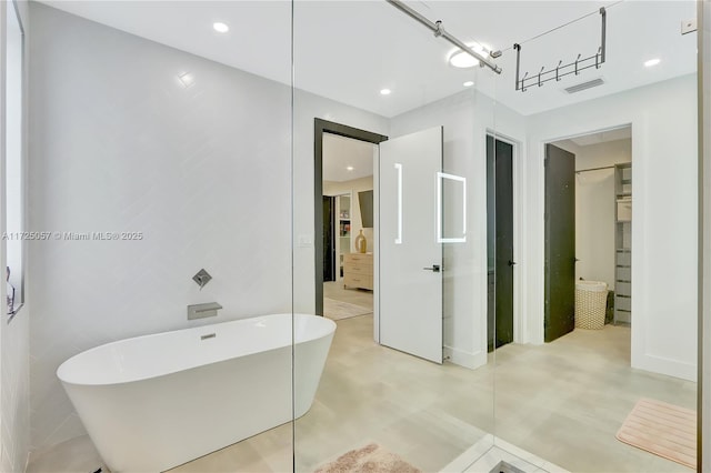 bathroom featuring a soaking tub, visible vents, and recessed lighting