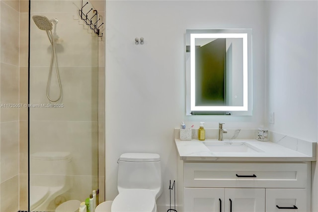 full bathroom featuring tiled shower, vanity, and toilet