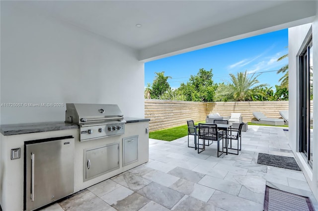 view of patio / terrace with area for grilling, outdoor dining area, grilling area, and a fenced backyard