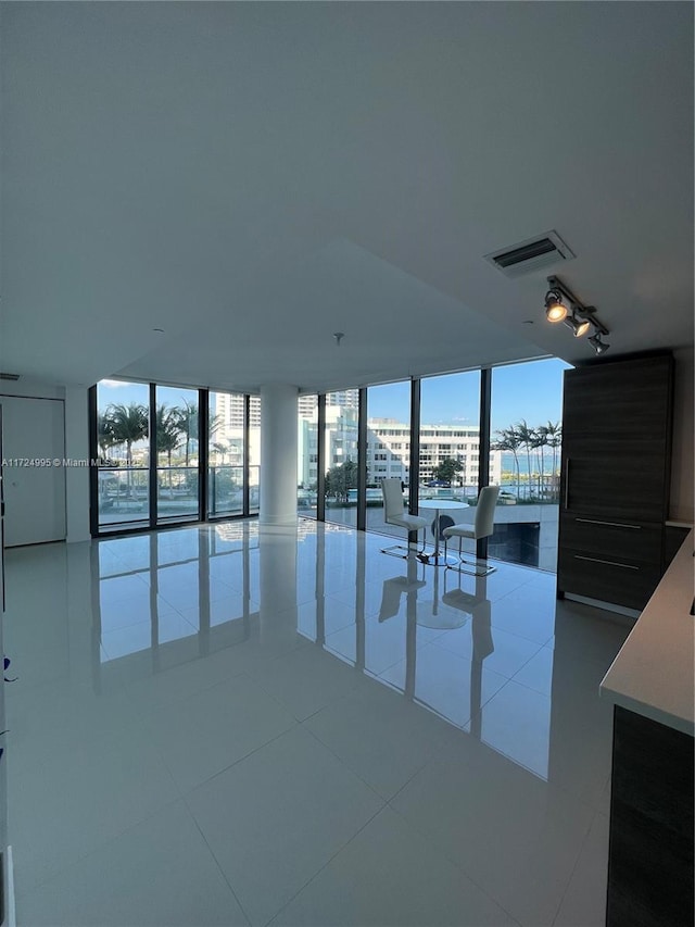 tiled spare room with floor to ceiling windows and plenty of natural light