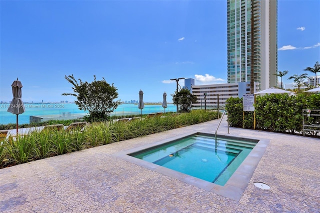 view of swimming pool with a community hot tub and a water view