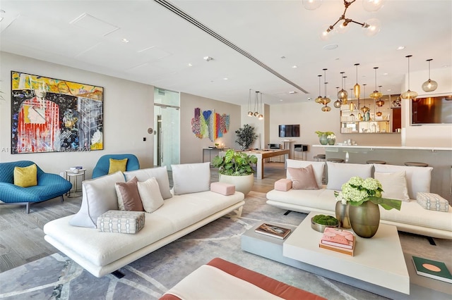 living room featuring wood-type flooring and a notable chandelier