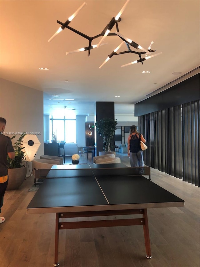 playroom with hardwood / wood-style flooring and an inviting chandelier