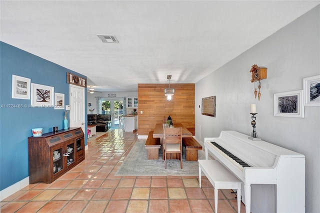 interior space with wooden walls and light tile patterned floors