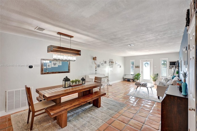 dining area with light tile patterned floors and a textured ceiling